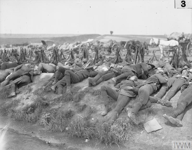 Battle of Bazentin Ridge 14 -17 July. A row of exhausted soldiers lying stretched on the ground after a tour of duty in the trenches.