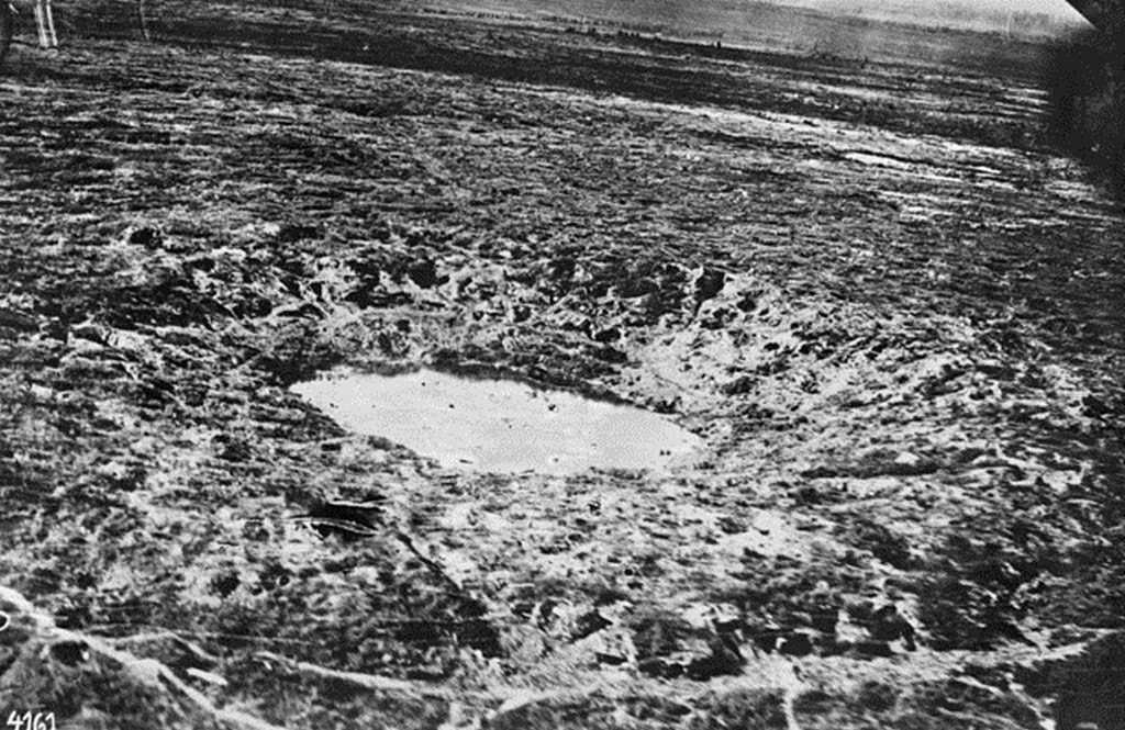 Wytschaete, Belgium. c. 1917. An enormous mine crater, named Heinrich, near the town photographed from a German observation balloon. Infantry dugouts are at the edge of the crater.