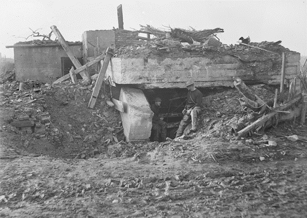 January 1918. View of a concrete dugout at Wytschaete damaged by the shellfire of some months before. The two soldiers in the foreground are unidentified.