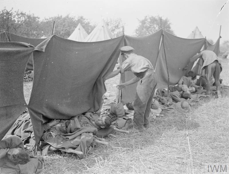 Battle of Amiens. Arranging blankets to shade from the sun wounded awaiting evacuation from a Field Dressing Station at Le Quesnel, 11 August 1918. © IWM (Q 7299)