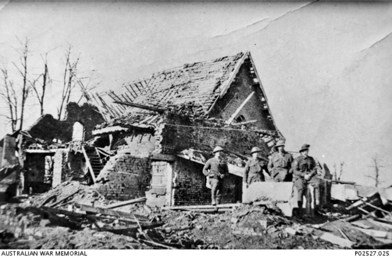 Le Bizet, France/Belgium border. 1917. Members of 107th Australian Howitzer Battery standing in front of the remains of the damaged building used as Headquarters.