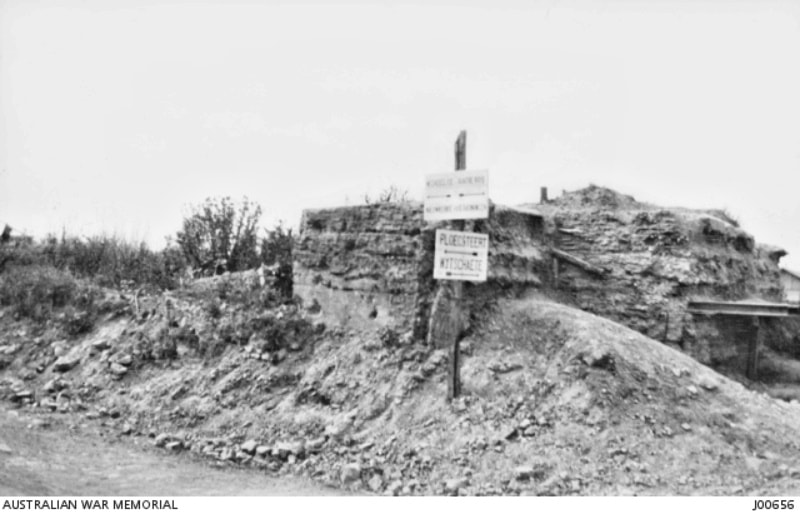 Post war; A German Pillbox on the Messines Road. The signboard reads: 'Ploegsteert Wytschaete'.